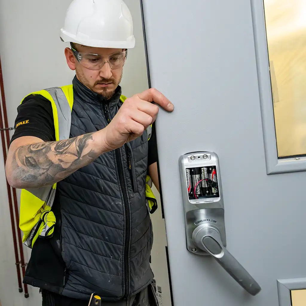 fire door installer checking electronic security lock on door